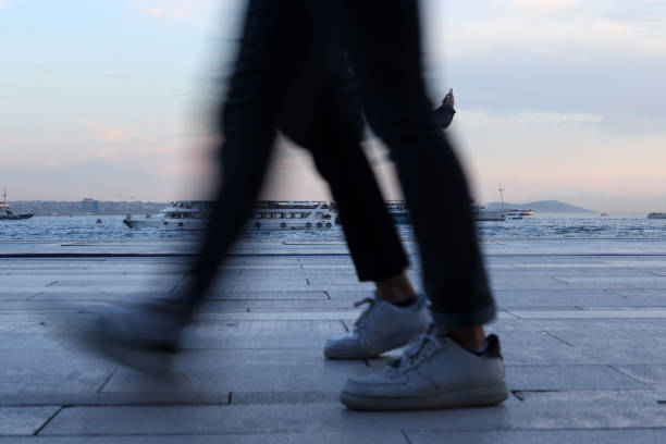 Low Section Of Man Walking On Footpath