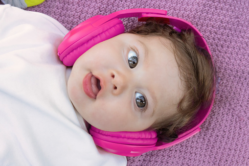 Portrait of a baby with pink hearing aids