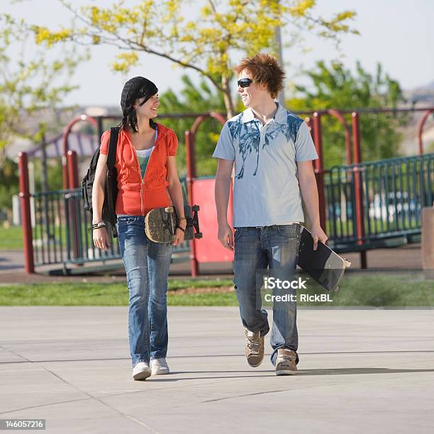 Teens Couple Walks Stock Photo - Download Image Now - Boys, Skateboard Park, Teenage Girls