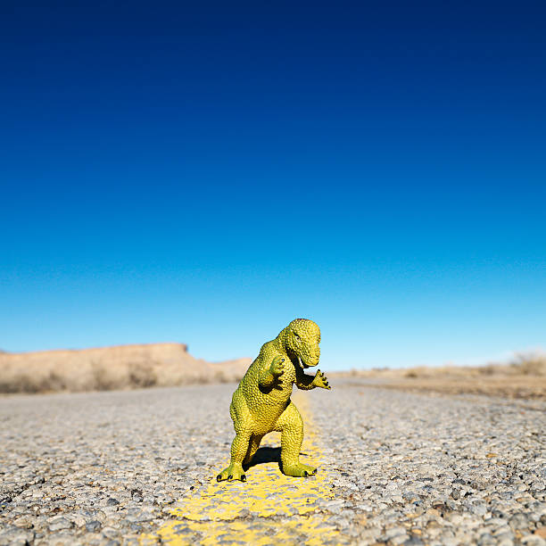 Toy dinosaur in road.