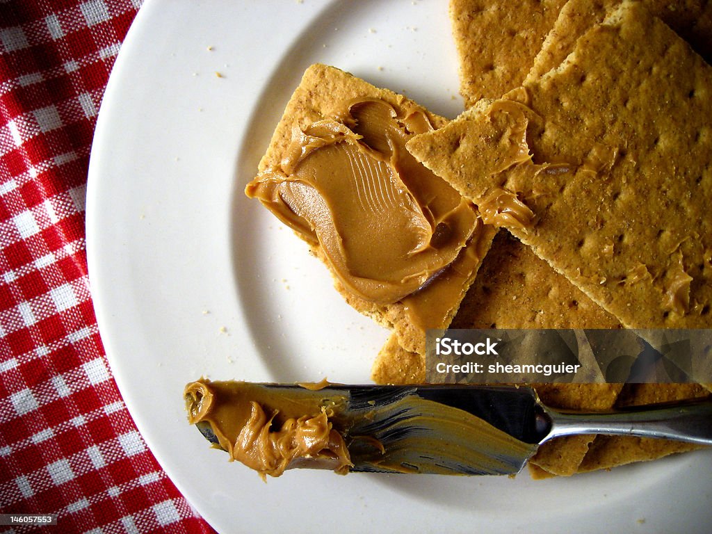 Peanut Butter, Graham Cracker Peanut butter and graham crackers on red background Cracker - Snack Stock Photo