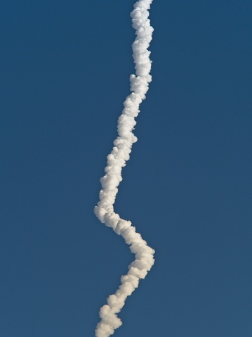 Falcon 9 rocket contrail illuminated in early morning light on the Space Coast of Florida. The contrail from the rocket launch shines brightly against the dark sky of the pre dawn launch January 18, 2023.