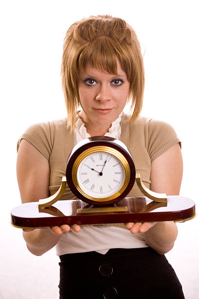 Joven mujer sosteniendo un reloj - foto de stock