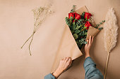 Wrapping a bouquet with red roses for Mother's Day
