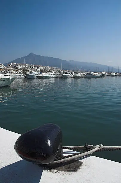 Ship's mooring rope around a bollard, quayside in Puerto Banus, Spain.