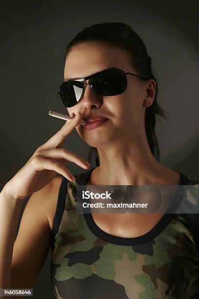 Foto de Menina Sensual Em Camuflagem Com Cigarro e mais fotos de stock de Acessório - Acessório, Adolescência, Adulto