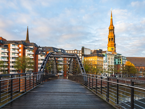 Kibbelstegbrücke wooden bridge over Zollkanal and Hauptkirche St. Katharinen tower in Hamburg, Germany