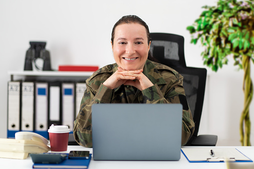 Cropped shot of an attractive young female soldier in her office and looking at camera
