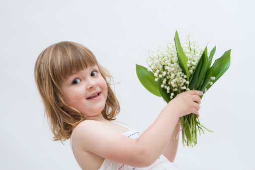 little, pretty girl with big bunch of flowers, isolated on white