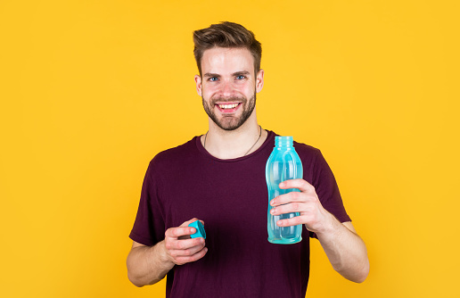 hydrate your body. hydration and hydro-balance. sport and health. refreshing while fitness. water balance in body. healthcare. man drink water after active training. handsome guy hold water bottle.