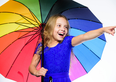 Teenage girl with colorful umbrella. Wearing red sneakers.