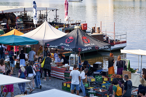 Prague, Czech Republic - August 13, 2022: People shopping at the Naplavka farmers market at Vltava riverbank