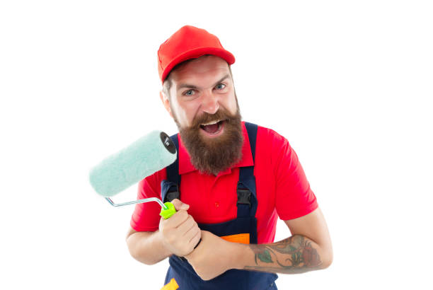 istock angry man painter with paintroller in uniform. bearded man painter with paintroller in studio. 1460592560
