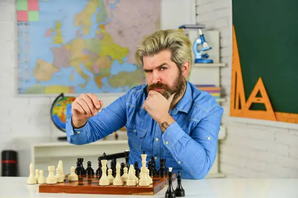 Chess Federation. Schoolboard fun. teacher make training lesson. education concept. mature man playing intellectual game. clever man play chess. chess board with chess pieces. tournament strategy.