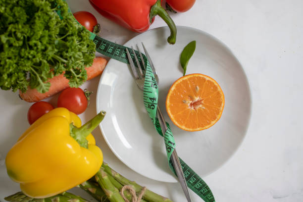 istock Plate, fork, measuring tape vegetables and fruits 1460593037
