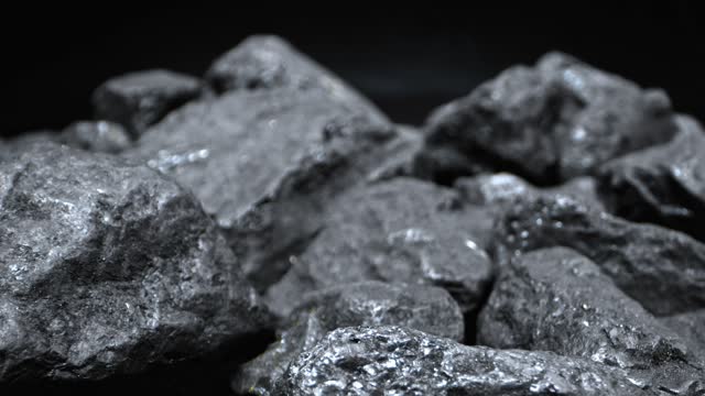 Close-up of lumps of coal. Sulfur on coal nuggets. Backwards dolly shot. 2