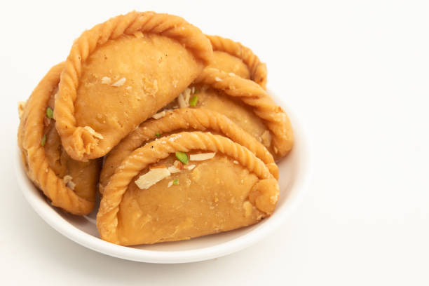 indio mithai gujia también llamado gujiya, pirukiya, pirukia, pedakiya, karanji, basundi gughra hecho de suji ghee relleno con mawa khoya chasni mava khoa se disfruta en deepawali, teez, holi y teej - gujia fotografías e imágenes de stock