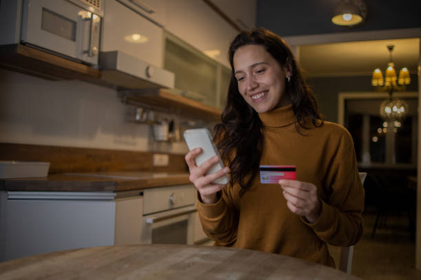 istock Cheerful  young woman doing online shopping 1460594784
