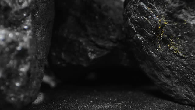 Close-up of lumps of coal with traces of sulfur. Backwards dolly shot.