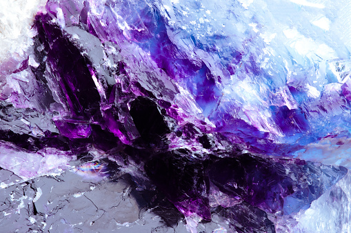 fluorite, purple and blue macro detail texture background. close-up raw rough unpolished semi-precious gemstone.