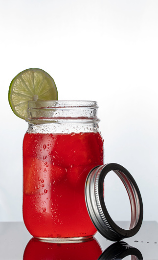 Watermelon agua fresca drink with lime slice on side of container
