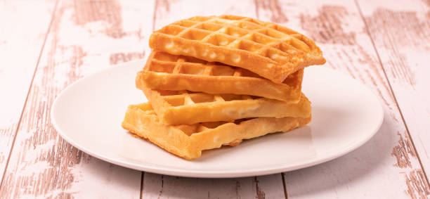 istock Delicious Belgian waffles served on white plate and wooden background, rustic concept, space for text 1460600122