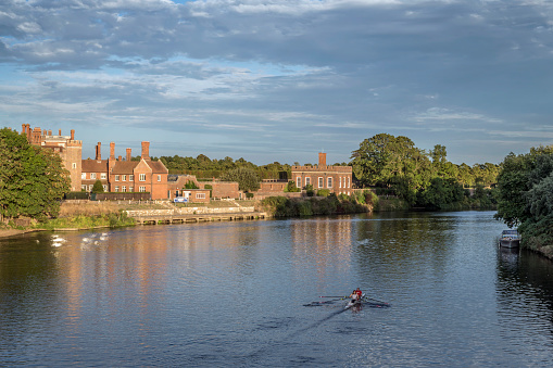 Hampton Court View at sunset  in mid summer image taken from river bridge a popular visiting place for tourists coming from all over the world to witness the historic Tudor architecture Hampton Court and the royal Bushy Park again all in walking distance