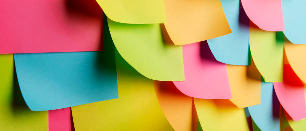istock colorful office sticky notes with curled corners pasted on the wall. Minimalistic concept of excessive workload. 1460604584