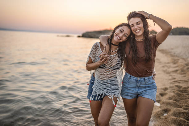Photo of female friends walking at the beach and enjoying their summer vacation.