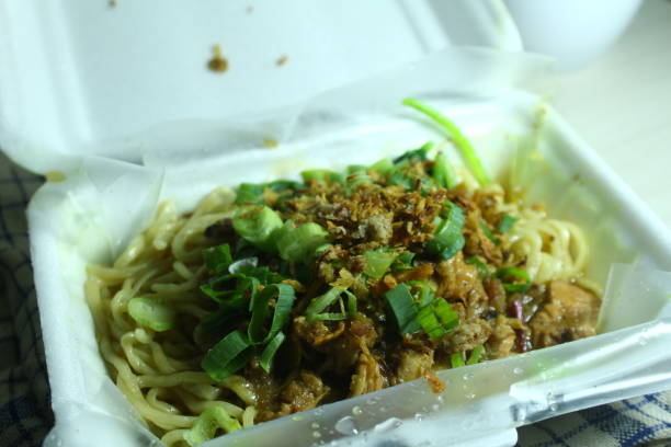 Mie ayam, typical Indonesian food,noodles with chicken and vegetables in a styrofoam box Asian food delivery, street food concept