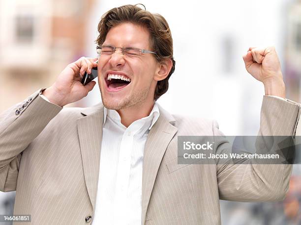 Excited Young Businessman With Eyes Closed Talking On Mobile Phone Stock Photo - Download Image Now