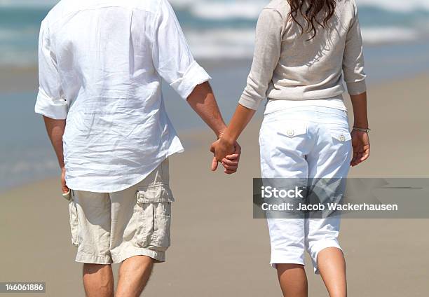 Midsection View Of Couple Walking With Holding Hands On Beach Stock Photo - Download Image Now