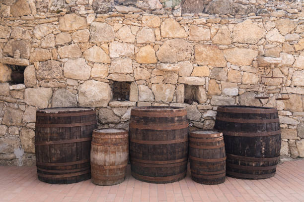 Old wooden barrels on a real stone wall surface background
