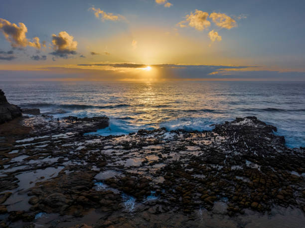 istock Sunrise over the ocean and rock platform 1460625510