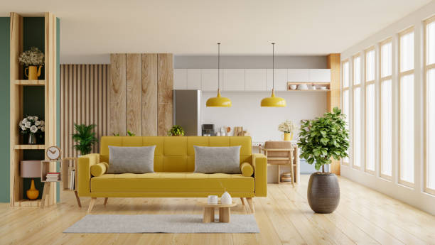 Living room interior in warm tones with yellow sofa which is behind the kitchen.