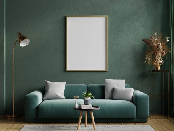 istock Poster mockup with vertical frame on empty dark green wall with green velvet sofa. 1460633067
