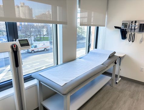 Background image of hospital room interior with bed against pale blue wall, copy space