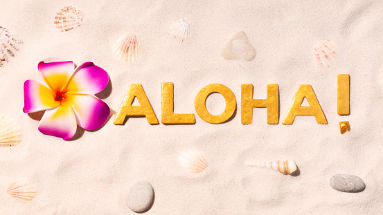 Aloha! - Hawaiian language greeting by gold letters on white sand