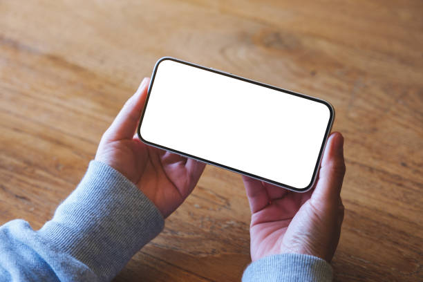 istock Top view mockup image of a woman holding mobile phone with blank desktop screen 1460654852