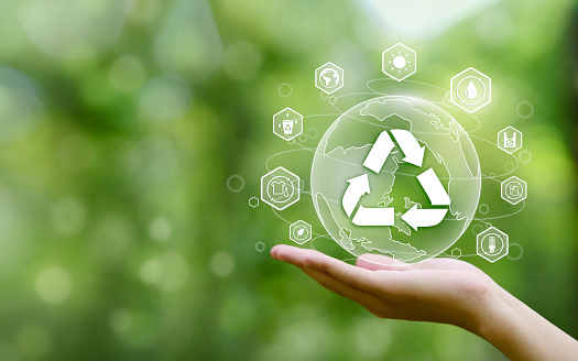 Mano sosteniendo la tierra sobre un fondo verde con icono reciclar en el concepto de reutilización reducir reciclar podredumbre desechar. Cero residuos. Consumo consciente. photo