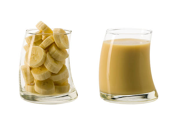 Glass of banana slices next to a glass of banana juice