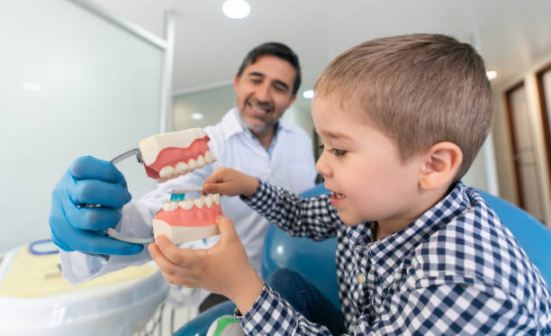 istock Happy boy at the dentist learning how to brush his teeth 1460670826