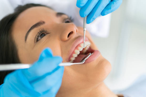 istock Woman getting her teeth cleaned at the dentist 1460670956