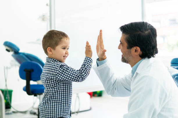 istock Young patient giving a high-five to his dentist 1460670960