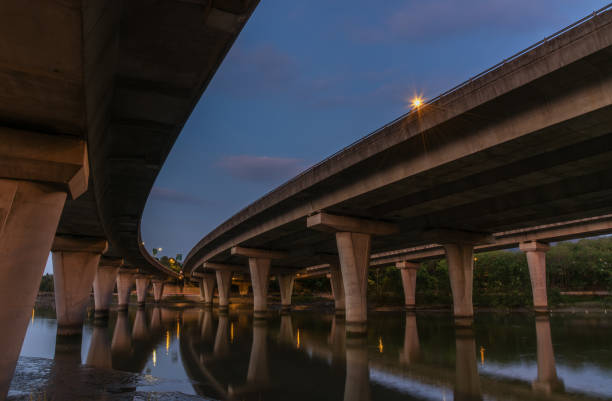 istock Underside of an elevated road across river at dusk 1460674291