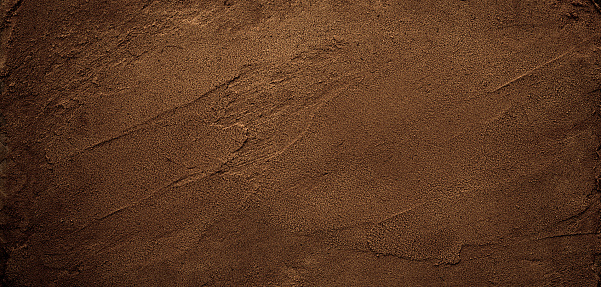 Dark chocolate brown sugar-like grainy texture background.