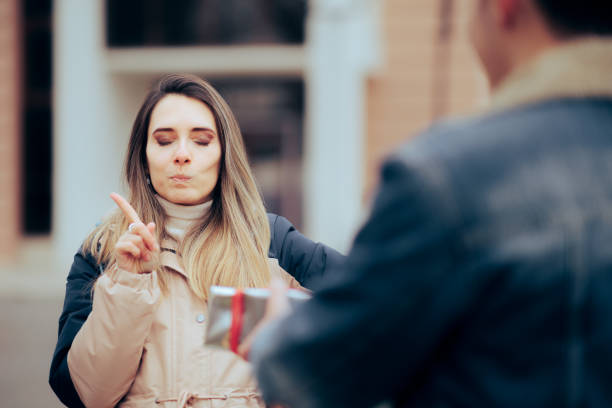 istock Annoyed Woman Refusing an Unwanted Gift from her Admirer 1460681524