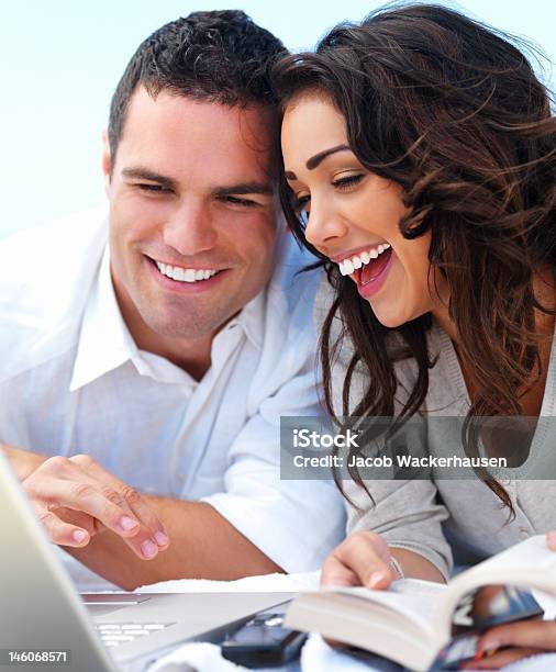 Foto de Closeup De Um Casal Jovem Feliz Olhando Para Laptop e mais fotos de stock de 20 Anos