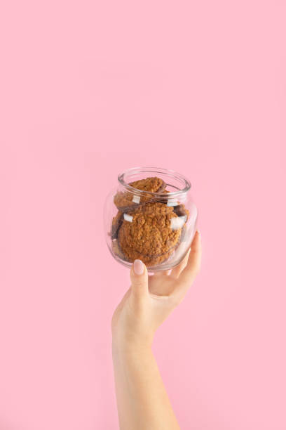 istock Arms raised up holding coffee cup on pink background. 1460685735