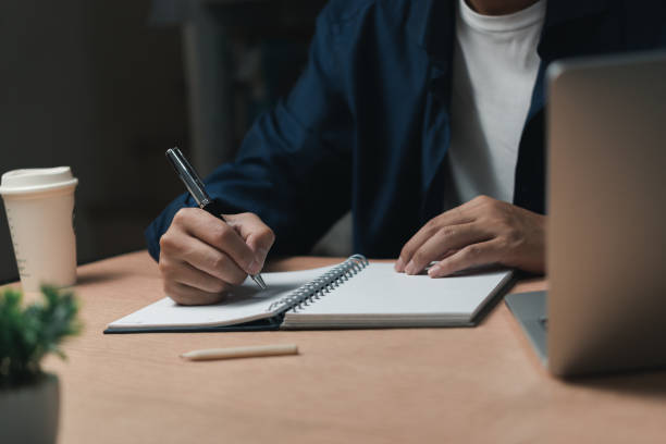 istock Businessperson reading and writing on book.education studying knowledge development and cognition learning concept. 1460687449